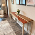 Sofa table scene showcasing a walnut river epoxy console table with volcanic pearlescent resin inlay and dramatic natural grain.