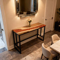 Contemporary hallway interior with a walnut epoxy resin sofa table, volcanic pearlescent resin swirl, and warm ambient lighting.