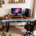 Black walnut epoxy resin desk in a home office, featuring an ocean-wave resin river with blue marbling and glossy finish.