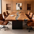 Modern meeting room scene featuring a black walnut epoxy resin conference table and brown leather chairs.