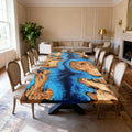 Olive wood epoxy resin dining table in a formal dining room, featuring a deep blue river epoxy with marbled swirl pattern and live edge slabs.