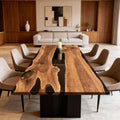 Walnut epoxy resin table in a modern living room, featuring a glossy black river epoxy and rich natural wood grain.