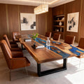 Bright modern living room setting featuring a black walnut epoxy resin table with a flowing blue river design and sleek metal base.