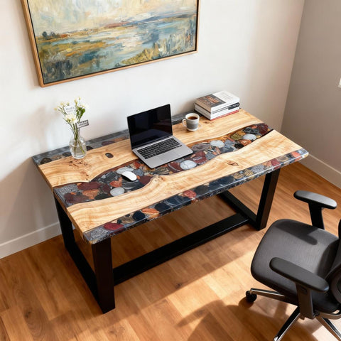 French poplar live-edge epoxy desk with a transparent pebble river inlay, set up for remote work with laptop and books.
