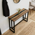 Modern living room scene with a black walnut black river epoxy sofa table, styled behind the couch with minimalist decor accents.