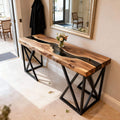 Walnut epoxy resin console table behind a sofa, featuring a deep black resin river inlay with glossy finish and rich natural grain.