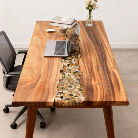 Walnut epoxy resin desk featuring a pebble-filled stream river design, styled in a modern home office with laptop workspace.