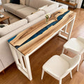 Walnut epoxy resin dining table styled for entertaining, featuring a vivid royal blue resin river design and dramatic grain patterns.