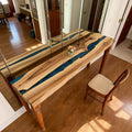 Open-concept home interior showcasing a walnut royal blue epoxy table with high-gloss finish and statement tabletop character.