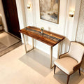 Walnut epoxy resin dining table styled for entertaining, featuring a flowing silver-gray resin river and dramatic walnut grain patterns.
