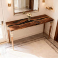 Black walnut epoxy resin dining table styled for entertaining, featuring a flowing black resin river and warm walnut figure.